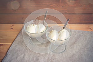 Vanilla ice cream in glass bowls with spoons