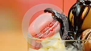 Vanilla ice cream macro closeup with chocolate sauce and macron cookies.
