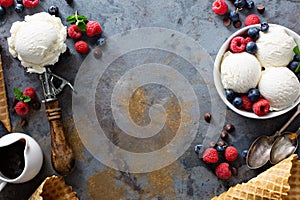 Vanilla ice cream scoops in a bowl with fresh berries