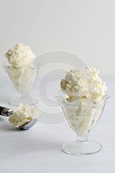 Vanilla ice cream scoops in glass dish