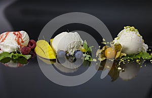 Vanilla ice cream scoops with strawberry syrop, blueberries, nuts and mango