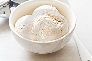 Vanilla ice cream scoops in white bowl