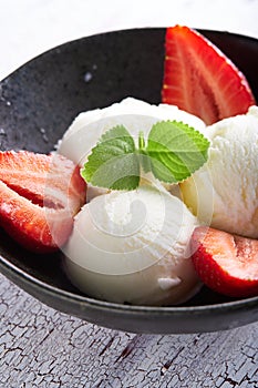 Vanilla ice cream with strawberries and almonds served in a plate