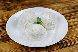 Vanilla ice cream in white plate on wooden table