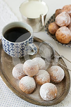 Vanilla krapfen doghnut with coffee. Rustic style.