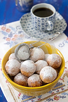 Vanilla krapfen doghnut with coffee. Rustic style.