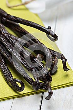 vanilla pods on green napkin and wooden background