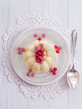 Vanilla pudding with red currants on a plate photo