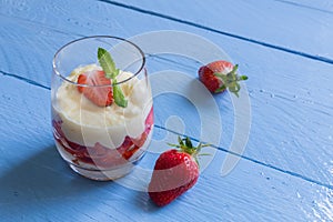 Vanilla pudding with tipsy strawberries on wood photo