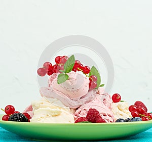 Vanilla and raspberry ice cream scoops on a round green plate