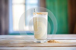 vanilla shake in a frosty glass with a drip down the side on a wood surface