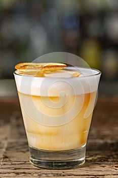 Vanilla Sour cocktail with egg white and lemon juice  on the bar