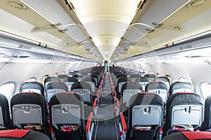 Vanishing row of black and red seats in airplane.