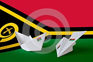 Vanuatu flag depicted on paper origami airplane and boat. Handmade arts concept