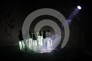 Vape concept. Smoke clouds and vape liquid bottles on dark background. Light effects. Useful as background or vape advertisement.