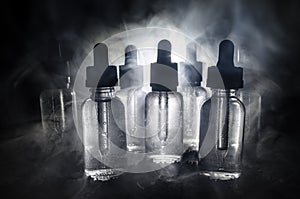 Vape concept. Smoke clouds and vape liquid bottles on dark background. Light effects. Useful as background or vape advertisement.