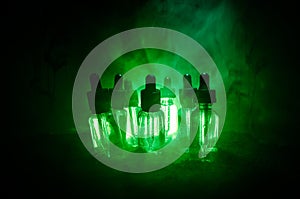 Vape concept. Smoke clouds and vape liquid bottles on dark background. Light effects. Useful as background or vape advertisement.