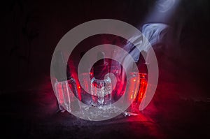 Vape concept. Smoke clouds and vape liquid bottles on dark background. Light effects. Useful as background or vape advertisement.