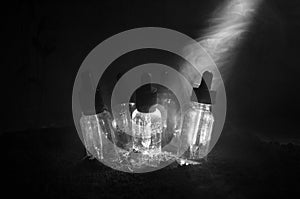 Vape concept. Smoke clouds and vape liquid bottles on dark background. Light effects. Useful as background or vape advertisement.