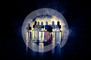Vape concept. Smoke clouds and vape liquid bottles on dark background. Light effects. Useful as background or vape advertisement o