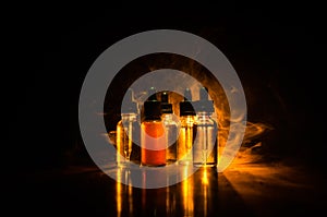 Vape concept. Smoke clouds and vape liquid bottles on dark background. Light effects. Useful as background or vape advertisement o