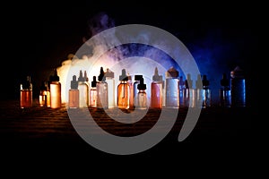 Vape concept. Smoke clouds and vape liquid bottles on dark background. Light effects. Useful as background or vape advertisement o