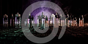 Vape concept. Smoke clouds and vape liquid bottles on dark background. Light effects. Useful as background or vape advertisement o