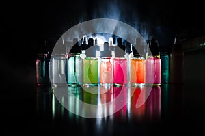 Vape concept. Smoke clouds and vape liquid bottles on dark background. Light effects. Useful as background or vape advertisement o