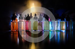 Vape concept. Smoke clouds and vape liquid bottles on dark background. Light effects. Useful as background or vape advertisement o