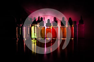 Vape concept. Smoke clouds and vape liquid bottles on dark background. Light effects. Useful as background or vape advertisement o