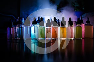 Vape concept. Smoke clouds and vape liquid bottles on dark background. Light effects. Useful as background or vape advertisement o