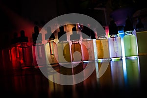 Vape concept. Smoke clouds and vape liquid bottles on dark background. Light effects. Useful as background or vape advertisement o