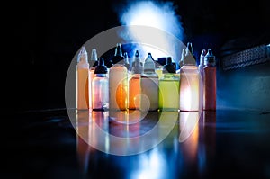 Vape concept. Smoke clouds and vape liquid bottles on dark background. Light effects. Useful as background or vape advertisement o