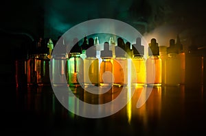 Vape concept. Smoke clouds and vape liquid bottles on dark background. Light effects. Useful as background or vape advertisement o