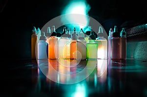 Vape concept. Smoke clouds and vape liquid bottles on dark background. Light effects. Useful as background or vape advertisement o