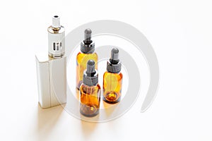 Vaping device e-cigarette electronic cigarette and liquid bottles isolated on white background. Vape device for alternative