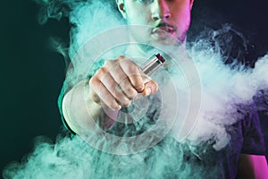 Vaping man holding a mod. A cloud of vapor.