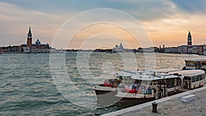 Vaporettos, Venice`s waterbus, and the skyline of the city at su