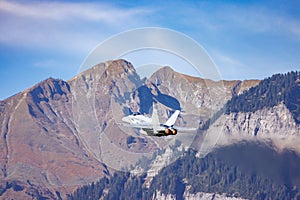 The vapour trail from a jet aircraft as it flies through the mountains