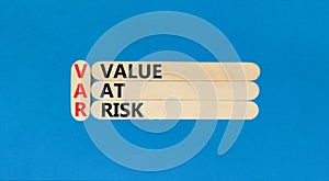 VAR Value at risk symbol. Concept words VAR Value at risk on beautiful wooden sticks. Beautiful blue table blue background.