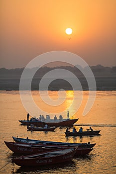 Pilgrims on boat floating on the waters of sacred river Ganges early morning.