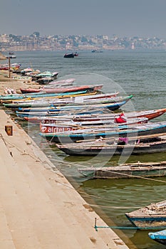 VARANASI, INDIA - OCTOBER 25, 2016: Small boats near Ghats riverfront steps leading to the banks of the River Ganges in