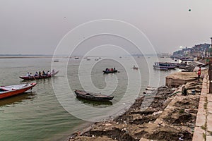 VARANASI, INDIA - OCTOBER 25, 2016: Small boats near Ghats riverfront steps leading to the banks of the River Ganges in