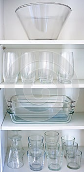 Varation of glasses standing in cupboard shelf
