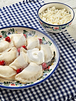 Varenyky filled with cottage cheese served with sour cream and c