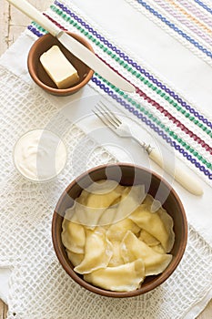 Varenyky, vareniki, pierogi, pyrohy or dumplings served with sour cream and butter.