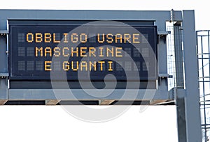 Variable message panel with the text which means the obligation to use masks and gloves in Italian language photo