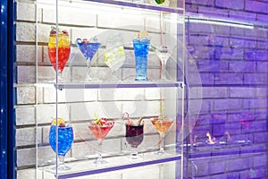 Variation alcoholic drinks served on bar counter. Colored drinks in glasses. Beautiful background, evening mood