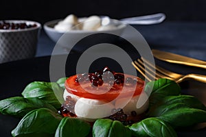 Caprese salad, mozzarella cherry tomatoes, basil, olive oil and balsamic photo