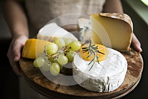 Variation of cheese and green grapes on a wooden platter food photography recipe idea